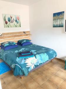 - une chambre avec un lit et une couette bleue dans l'établissement Les Chênes-lièges d'Ambeille, à Collioure