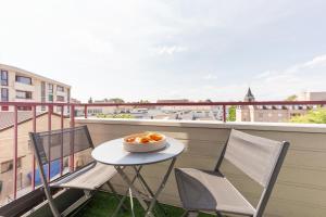 un balcón con mesa y sillas y un bol de fruta en Blue Dream - RER B&C - Netflix / Disney+/ Easy Check-in, en Massy