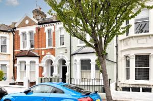 a blue car parked in front of a house at Family Home near Clapham Common by UnderTheDoormat in London