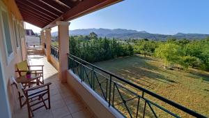 a balcony with two chairs and a view of a yard at Aloda Summer House in Roda