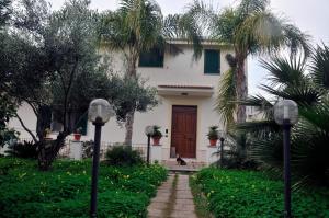 a house with a dog sitting in front of it at La Villa in Roccella Ionica +2 photos