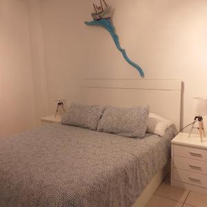 ein Schlafzimmer mit einem Bett mit einer blauen Eidechse an der Wand in der Unterkunft Formentera Suite 7 in Es Pujols