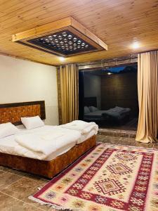 sypialnia z 2 łóżkami i dywanem na podłodze w obiekcie Wadi Rum Sand Camp w mieście Disah