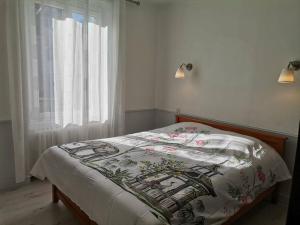 Un dormitorio con una cama con una manta. en Grande maison de ville 120 m2 veranda et jardin., en Saint-Ouen