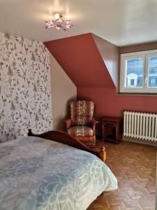 a bedroom with a bed and a chair and a window at Grande maison de ville 120 m2 veranda et jardin. in Saint-Ouen