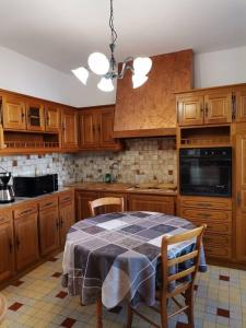 a kitchen with a table and a kitchen with wooden cabinets at Grande maison de ville 120 m2 veranda et jardin. in Saint-Ouen