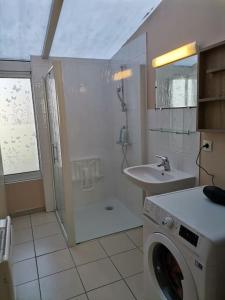 ein Badezimmer mit einer Waschmaschine und einem Waschbecken in der Unterkunft Grande maison de ville 120 m2 veranda et jardin. in Saint-Ouen