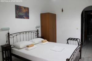 a bedroom with a bed with two towels on it at Rentoulia Apartments in Poulithra