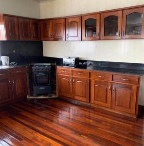 een keuken met houten kasten en een fornuis met oven bij Tweederijweg Apartments in Paramaribo