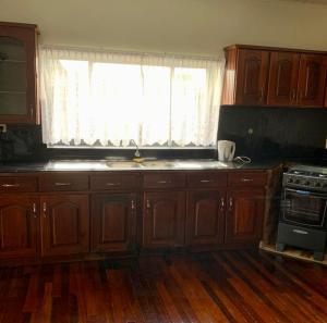 a kitchen with wooden cabinets and a window at Tweederijweg Apartments in Paramaribo