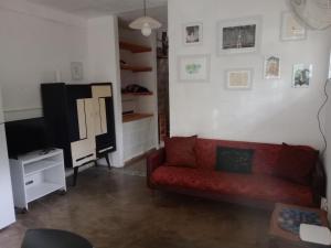 a living room with a red couch and a tv at Casa en Río Ceballos. Muy buena ubicación. in Río Ceballos