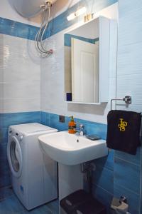 uma casa de banho com um lavatório e uma máquina de lavar roupa em Sea Salt Studio Apartment em Vlorë