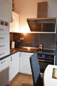 Una cocina con gabinetes blancos y un horno de estufa. en Sea Salt Studio Apartment, en Vlorë