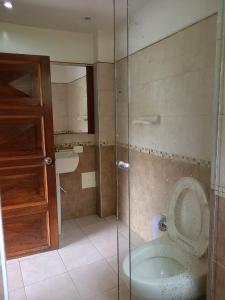 een badkamer met een toilet en een glazen douche bij The Frailejon House in Bogota