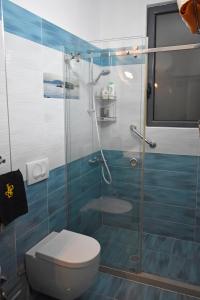 uma casa de banho com um WC e uma cabina de duche em vidro. em Sea Salt Studio Apartment em Vlorë