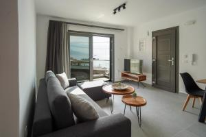a living room with a couch and a table at Sandy feet comfort suite in Kardamaina