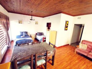 a living room with a dining table and a bedroom at The Yellow Butterfly in Vereeniging