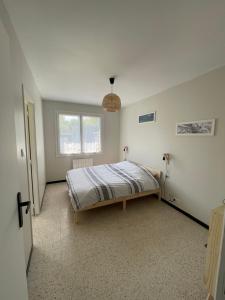 une chambre avec un lit et une fenêtre dans l'établissement Les Lucioles Fort-Mahon Plage, à Fort-Mahon-Plage