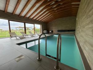 a swimming pool in a house with chairs at Casa Rural Nogalia in Villanueva de los Nabos