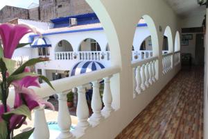 un balcón de una casa con valla blanca y flores en Hotel Villa del Rosario Nuevo, en Melgar