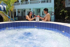 un homme et une femme assis dans un bain à remous dans l'établissement Hotel Villa del Rosario Nuevo, à Melgar