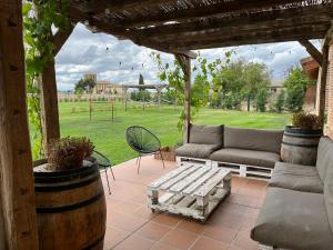 un patio con sofás, una mesa y un parque infantil en Casa Rural Nogalia, en Villanueva de los Nabos