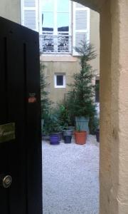 una porta aperta su un cortile con piante in vaso di Chambre d'hôte au 3ème étage d'une maison de chanoine ad Autun