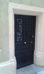 a black door on the side of a building at Chambre d'hôte au 3ème étage d'une maison de chanoine in Autun