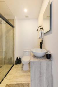 a bathroom with a white toilet and a sink at Departamento en Condominio Astoria in Acapulco