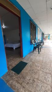 Una habitación con una pared azul con sillas y una cama en Miss Magi cahuita rooms, en Cahuita