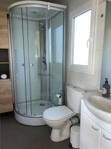 uma casa de banho com um chuveiro, um WC e um lavatório. em Mobile Home L&L em Drage