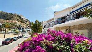 a street with purple flowers in front of a building at PARRALUE Beach front home in Benidorm