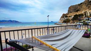 a bench on a balcony next to a beach at PARRALUE Beach front home in Benidorm