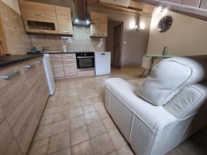 a living room with a white couch and a kitchen at Embrun Cosy in Embrun