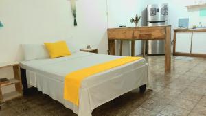 1 dormitorio con 1 cama con mesa y nevera en Miss Magi cahuita rooms en Cahuita