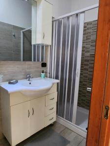 a bathroom with a white sink and a shower at Sicily Guest House in Gela