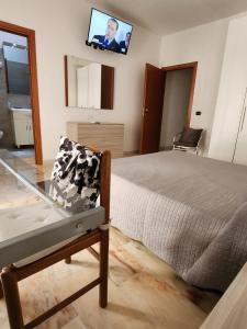 um quarto com uma cama e uma televisão na parede em Sicily Guest House em Gela
