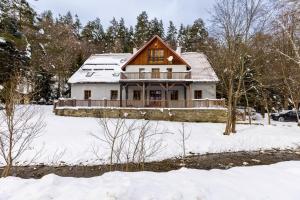 una casa nella neve con un terreno ricoperto di neve di Biały Dom W ROPKI a Ropki