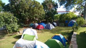a group of tents on the grass in a yard at Camping do Cid (no centro) in São Thomé das Letras