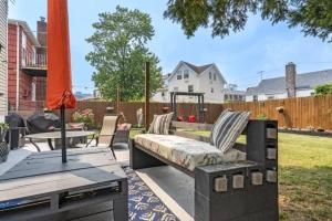 a patio with a bench and a table and an umbrella at Rockaway 3 bedroom suite by the Sea. in Wave Crest