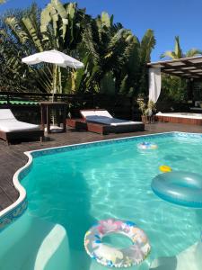 una piscina con dos inflables en el agua en Pousada Aloha Beach House, en Praia do Rosa