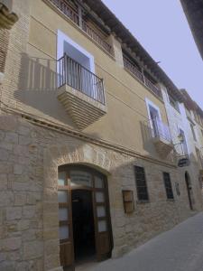 un edificio con una puerta y dos balcones. en Casa Jabonero en Alquézar