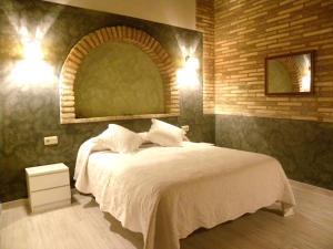 a bedroom with a bed with a brick wall at Casa Jabonero in Alquézar