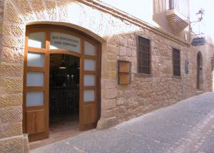 un edificio de piedra con una puerta con un cartel. en Casa Jabonero en Alquézar