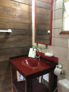a bathroom with a red sink and a mirror at Pousada Aloha Beach House in Praia do Rosa +139 photos