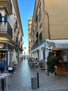 een stadsstraat met tafels, stoelen en gebouwen bij AM DEL SOL in Fuengirola