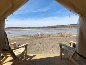 two benches sitting in a tent on a beach at Tentrr State Park Site - Nebraska Louisville SRA - Riverview D - Single Camp 