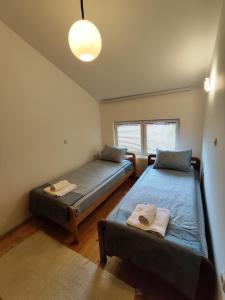 1 dormitorio con 2 camas y ventana en Villa Paradiso en Ohrid