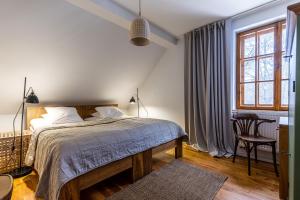 1 dormitorio con 1 cama, 1 silla y 1 ventana en Biały Dom W ROPKI en Ropki