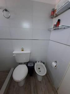 a white bathroom with a toilet and a sink at Depto céntrico de 3 habitaciones y cochera in Rosario